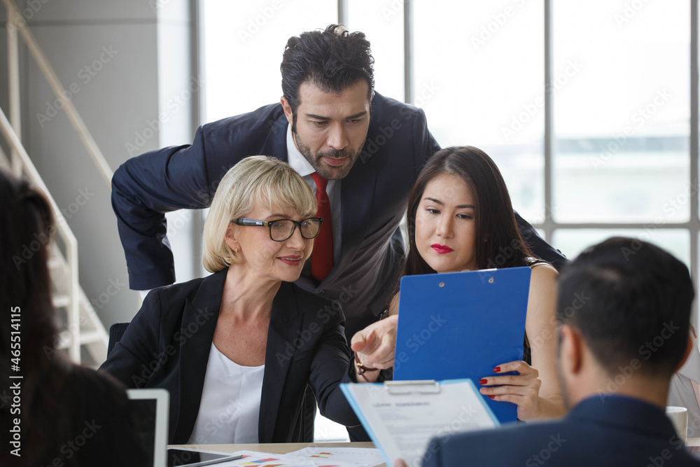 Group of business People Meeting with clipboard in office . marketing team Conference Brainstorming. worker standing and talking to colleague . Financial Teamwork discussing strategy at workspace.