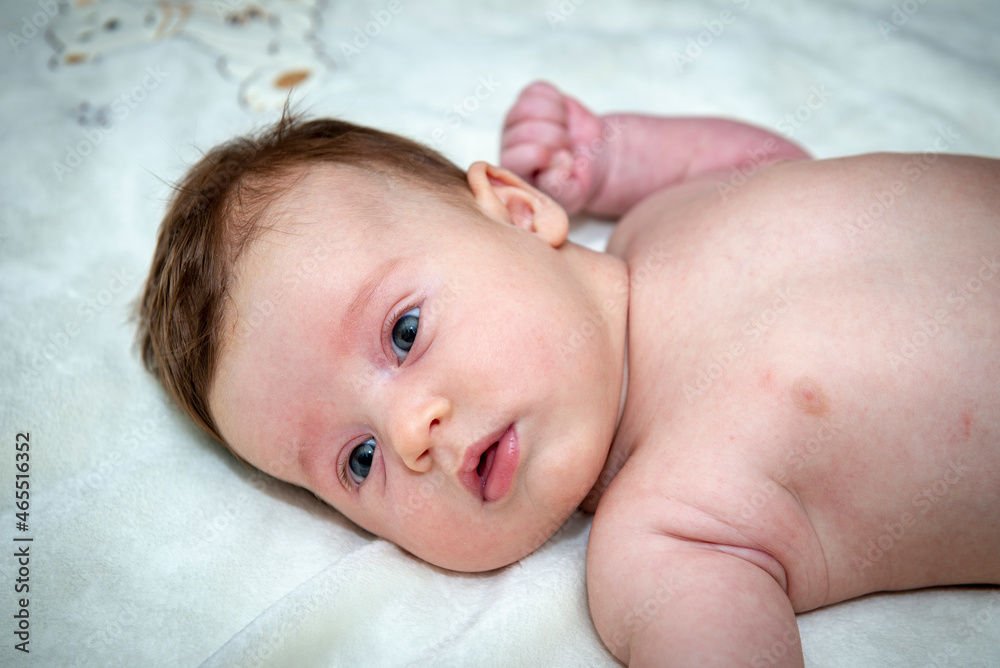 a little baby girl is lying on a big bed a little baby girl is lying on a big bed
