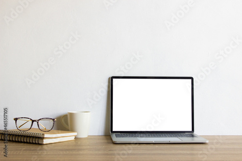 Mock up computer with books and coffee mug on table.  © aradaphotography