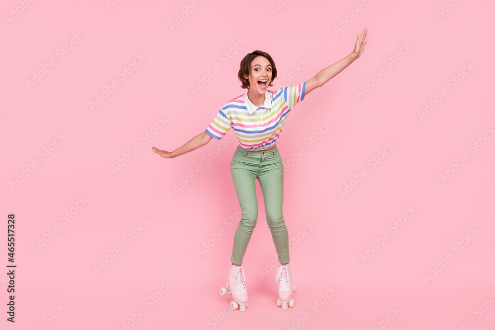 Full size photo of young girl happy smile amazed ride roller skates activity isolated over pink color background Full size photo of young girl happy smile amazed ride roller skates activity isolated over pink color background