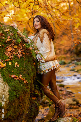 Autumn portrait with a beautiful woman in different positions near a mountain river.
