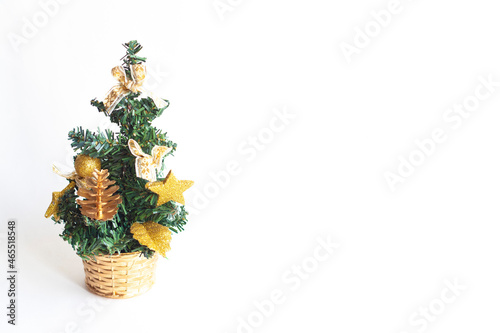 A small Christmas tree with toys in a basket isolated on a white background, copy space