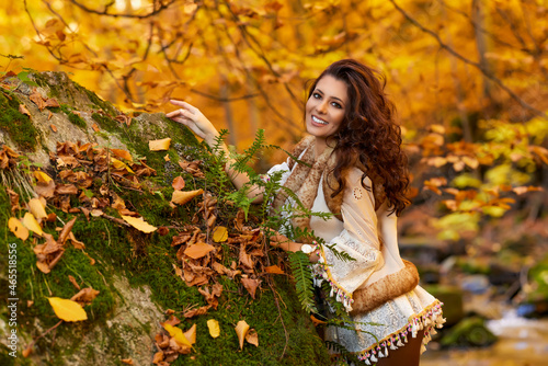 Autumn portrait with a beautiful woman in different positions near a mountain river.