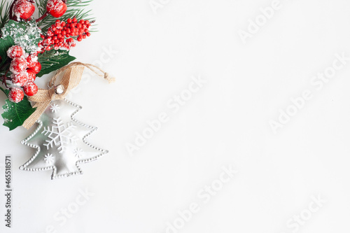 Christmas tree twig with red berries and Christmas tree toy on a white background, copy space