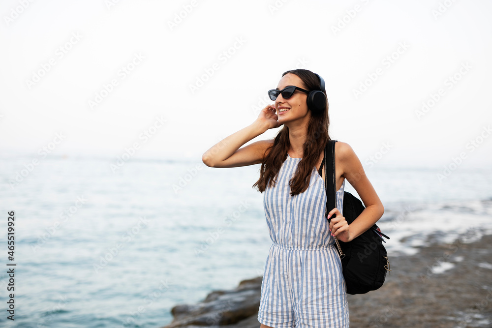 Hot woman relaxing on the sandy beach. Beautiful woman with headphones listening the music. Hot woman relaxing on the sandy beach. Beautiful woman with headphones listening the music.
