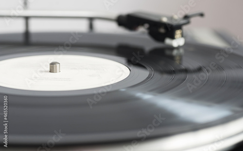 A spinning black vinyl record on a turntable. In motion. Selective focus.