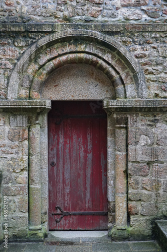 Red painted antique door at the entrance of a castle with a beautiful dome carved in stone