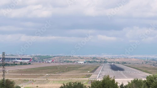 4K video with a panning showing a terminal of the Adolfo Suarez Madrid Barajas airport ending with the follow-up to an A321 bus of the Iberia airline taking off photo