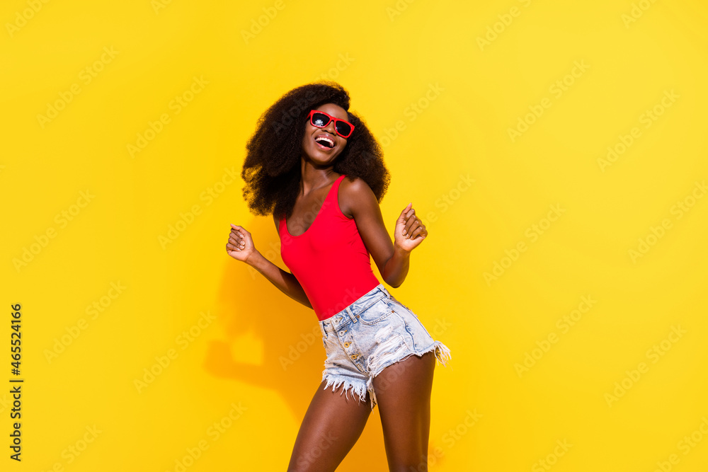 Photo portrait of dancing girl wearing red singlet shorts sunglass isolated bright yellow color background Photo portrait of dancing girl wearing red singlet shorts sunglass isolated bright yellow color background