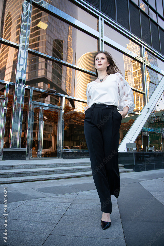 Young business woman on the street with glass mirror building behind Young business woman on the street with glass mirror building behind
