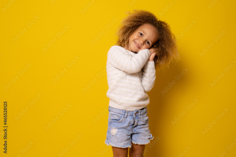 Beautiful little child girl sleep gesture posing with hands together smiling with looking at camera isolated over yellow background. Beautiful little child girl sleep gesture posing with hands together smiling with looking at camera isolated over yellow background.