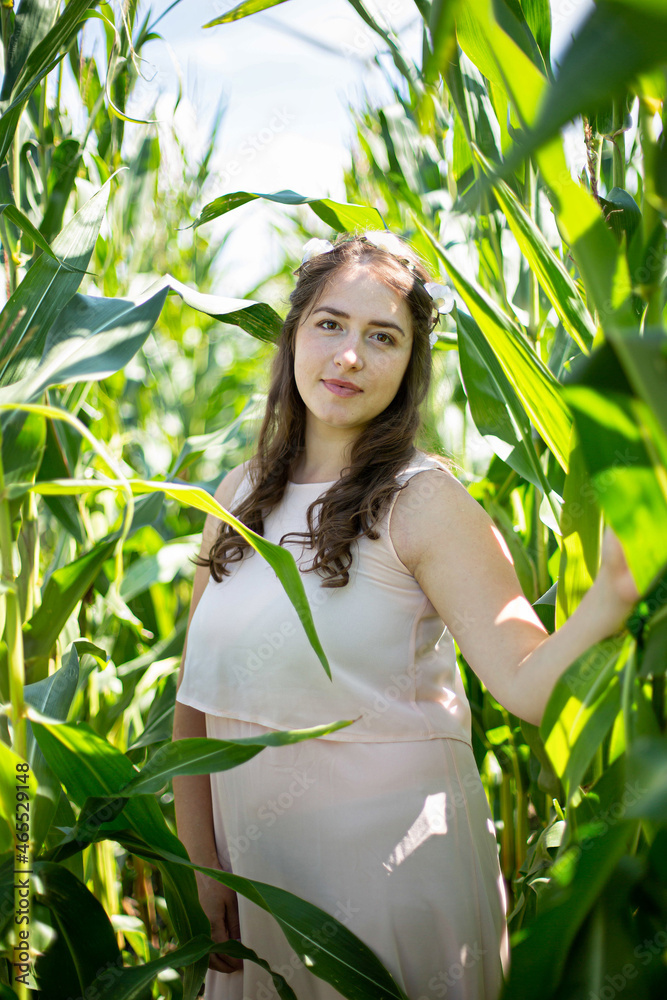 White young woman with long hair in light dress in the tall grass