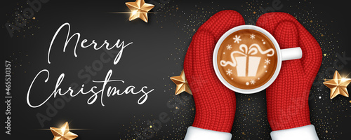 Hands in knitted mittens holding a cup of coffee. Christmas greeting card template