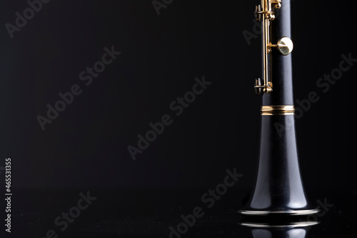 Tela A bell of a clarinet on a reflective surface with a dark background
