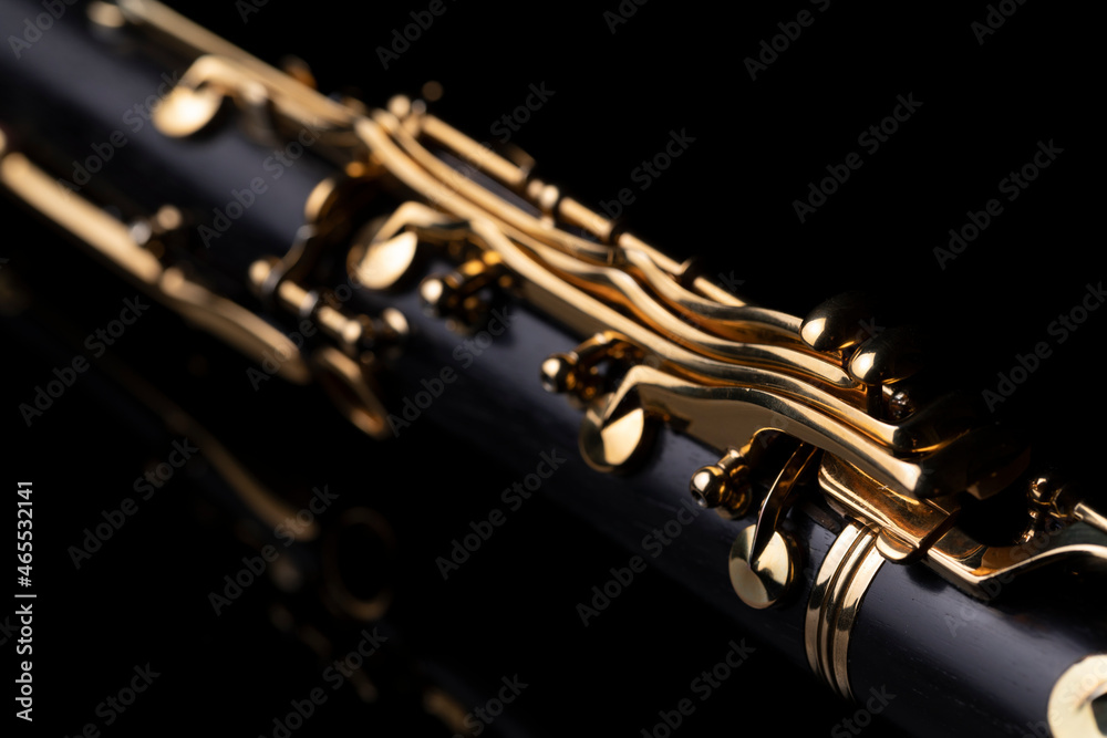 Naklejka premium Part of a clarinet with gold plated keys on a black background. A woodwind instrument common to classical music.