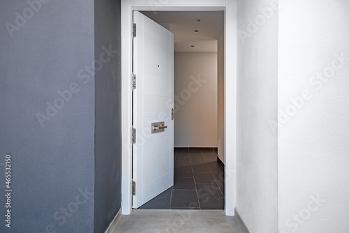 Open white door to the corridor of the house