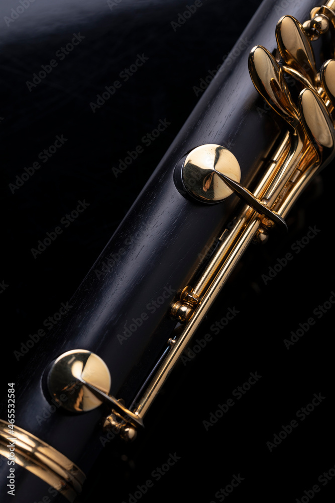 Naklejka premium Part of a clarinet with gold plated keys on a black background. A woodwind instrument common to classical music.