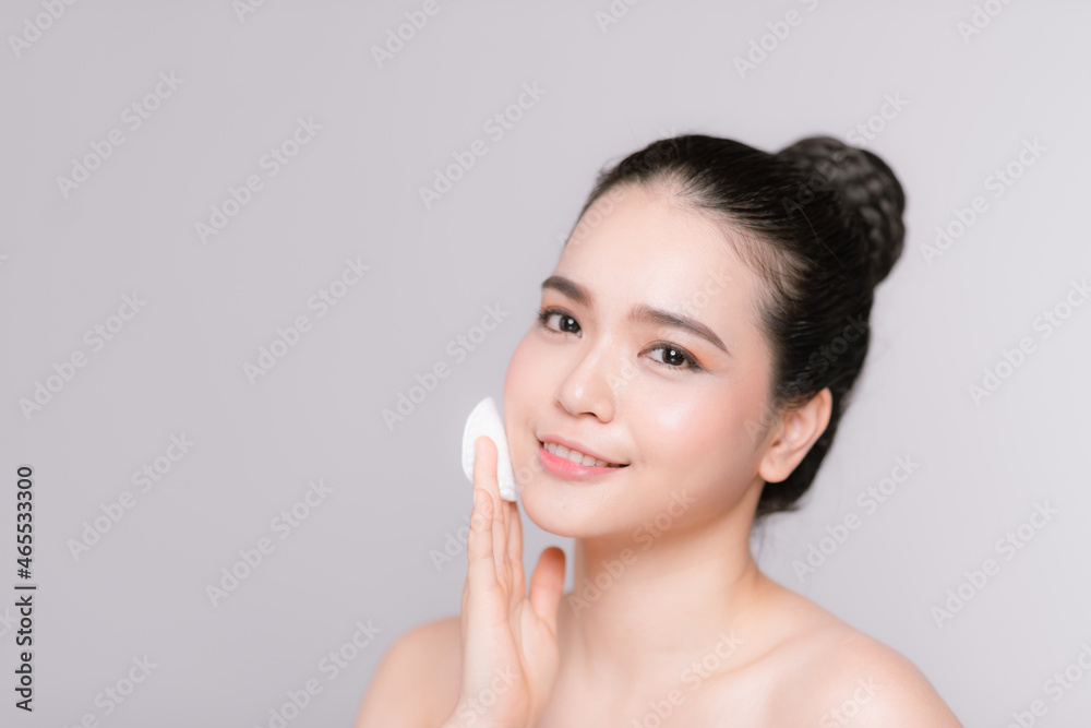 Smiling pretty young woman cleaning her face, using cotton pads and cleansing product, closeup Smiling pretty young woman cleaning her face, using cotton pads and cleansing product, closeup