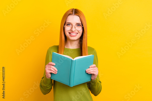Photo portrait red haired woman in glasses reading book isolated vivid yellow color background