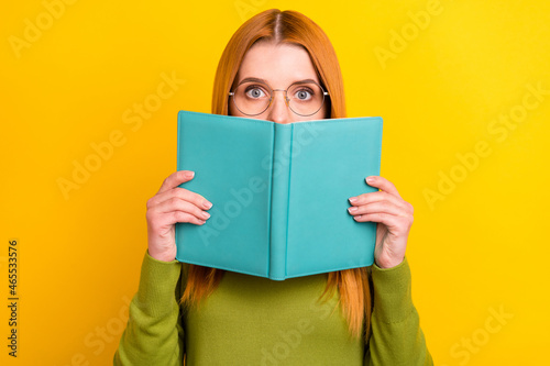 Photo of stressed red hair young lady hold book wear eyewear green sweater isolated on yellow color background