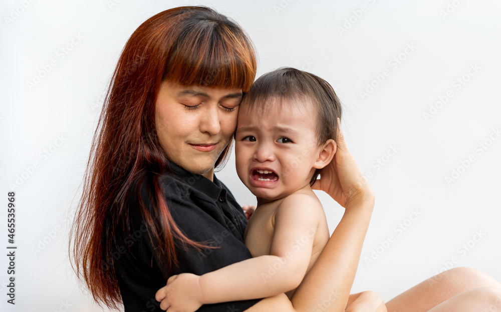 Baby crying while mom hugging. Woman embraces little frustrated son rear view snuggle to mother seeking for support protection of empathy and consoling concept, Family relationships concept Baby crying while mom hugging. Woman embraces little frustrated son rear view snuggle to mother seeking for support protection of empathy and consoling concept, Family relationships concept