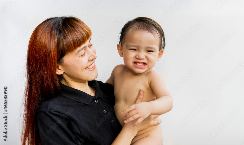 Happy mother with her baby on isolated white background. Mom wearing black shirt holding her son and smiling merrily. Young attractive happy mother smiling hugging looking at her little baby. Happy mother with her baby on isolated white background. Mom wearing black shirt holding her son and smiling merrily. Young attractive happy mother smiling hugging looking at her little baby.
