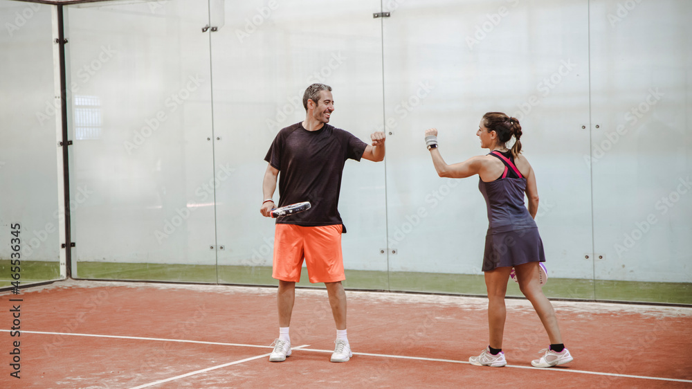 Woman and man celebrating a point on a paddle court