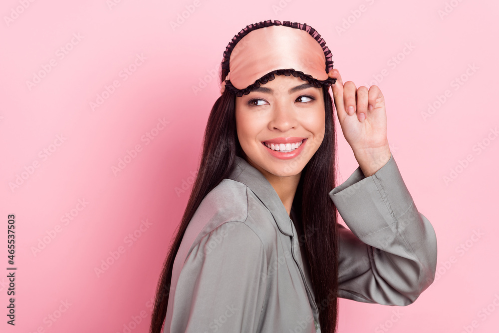 Profile side view portrait of attractive cheerful girl looking copy space touching blindfold isolated over pink pastel color background Profile side view portrait of attractive cheerful girl looking copy space touching blindfold isolated over pink pastel color background