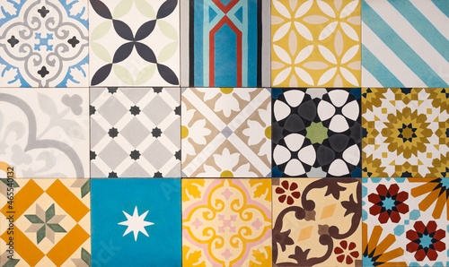 The background consists of several types of old colored tiles with different patterns