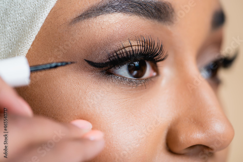 close up of young arabian woman applying black eye liner