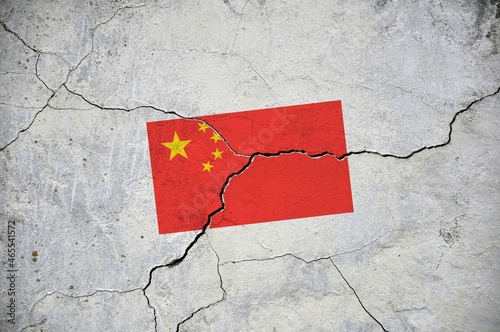 An old image of the flag of China on a wall with a crack.