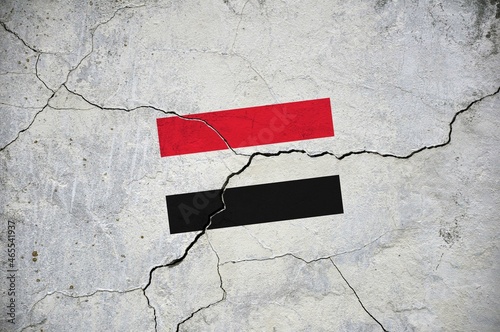 An old image of the flag of Yemen on a wall with a crack.