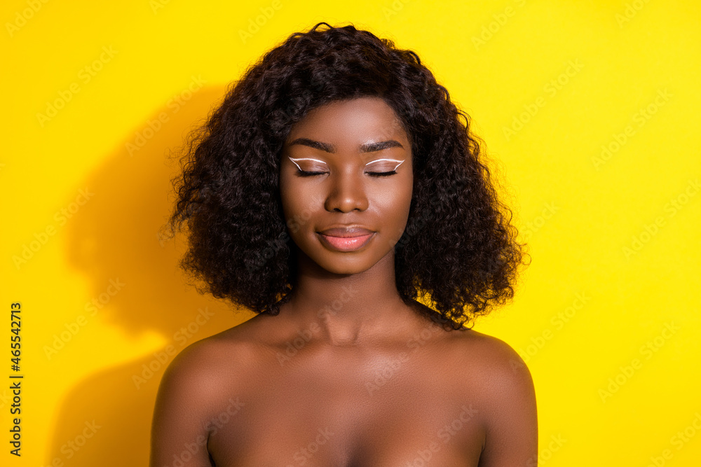 Photo of young beautiful charming dreamy peaceful afro woman wear no clothes isolated on yellow color background Photo of young beautiful charming dreamy peaceful afro woman wear no clothes isolated on yellow color background