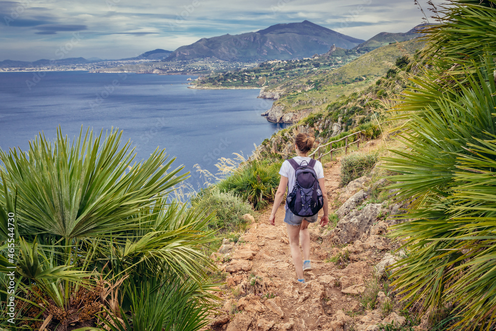 Tourist on a trail in Zingaro natural reserve on the shore of Castellammare Gulf on Sicily Island, Italy
