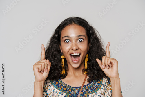 Young south asian woman screaming while pointing fingers upward