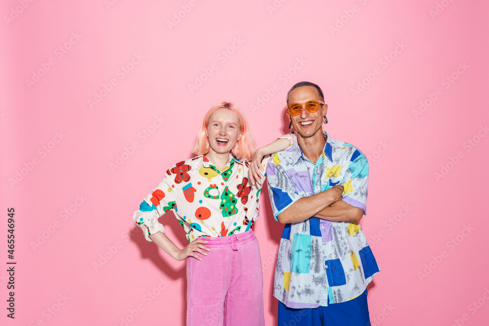 Young white couple in multicolored shirts laughing at camera Young white couple in multicolored shirts laughing at camera