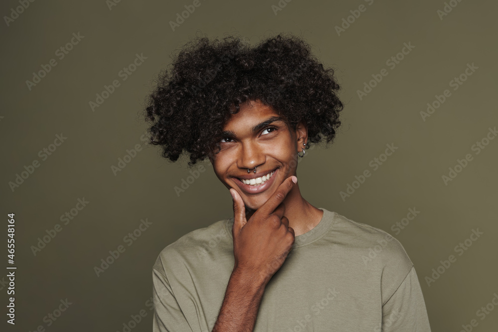 Young black man with piercing smiling and looking upward Young black man with piercing smiling and looking upward