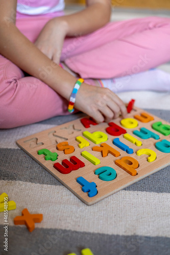 Child learns to put words out of letters. English alphabet. Eco friendly toy