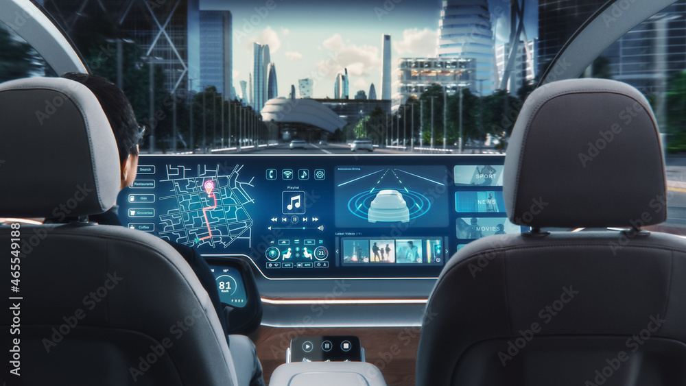 Futuristic Concept: Stylish Businessman Using Navigation App on an Augmented Reality Dashboard with Financial News Broadcast while Sitting in an Autonomous Self-Driving Zero-Emissions Electric Car. 