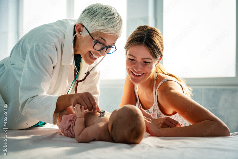 Pediatrician doctor examines baby. Healthcare, people, examination concept - obrazy, fototapety, plakaty 
