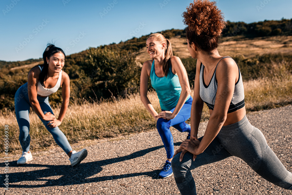Group of female friends stretching before running outdoors. Group of female friends stretching before running outdoors.