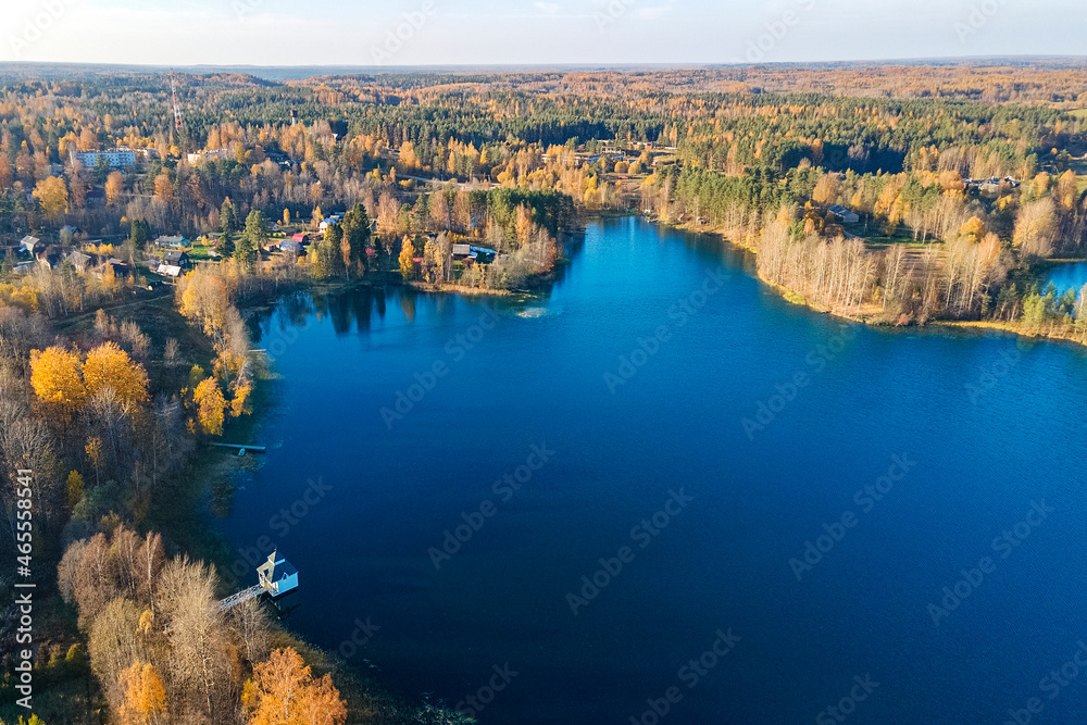 A small village of Tervenichi, autumn Forest and a lake with a font, Russia, Leningrad region.