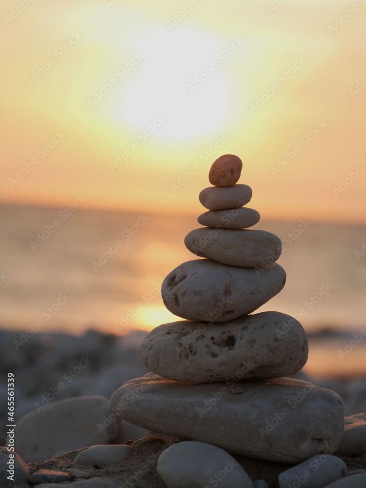 stack of pebbles facing the sunset over the ocean