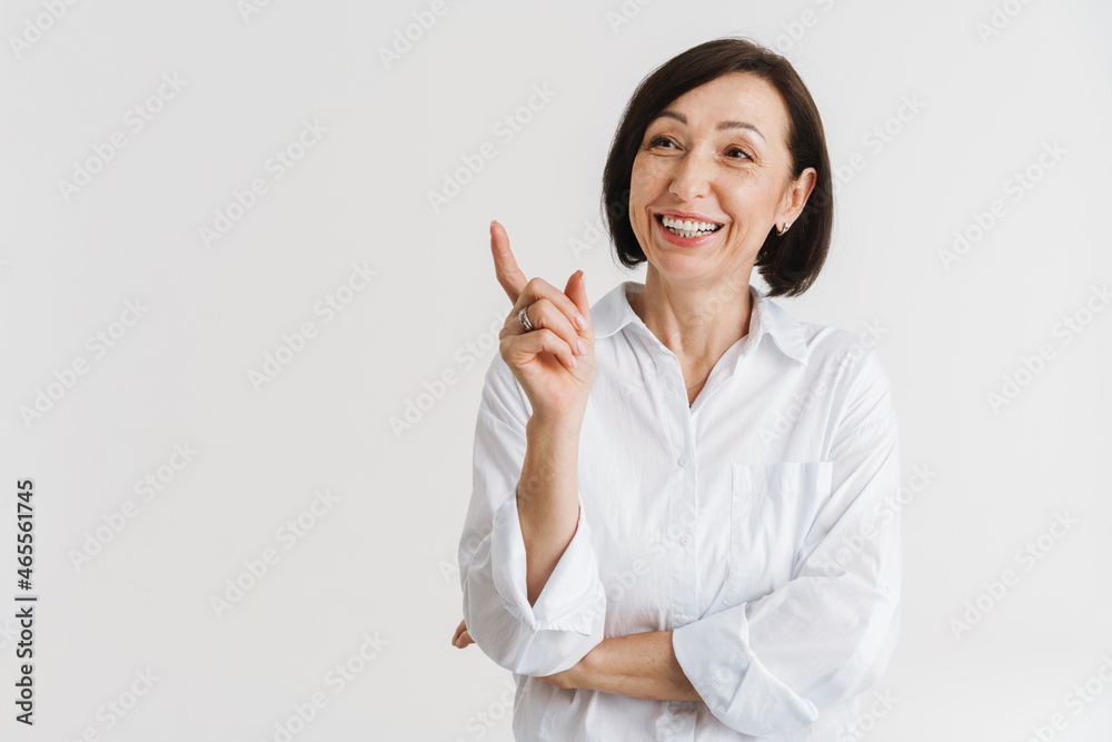 European mature woman laughing and pointing finger upward European mature woman laughing and pointing finger upward