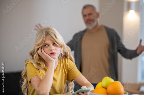 A blonde cute girl feeling frustrated while her father shouting at her