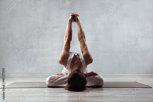 Strong man doing yoga asana