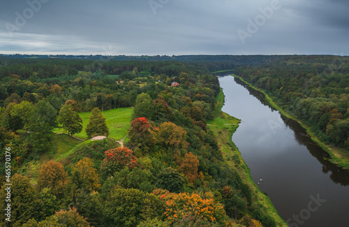 Punia mound in Lithuania with green grass and autumn trees background, road to mountain photo