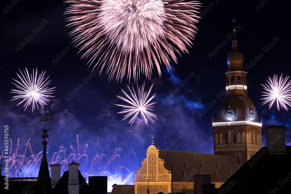 Riga cathedral from the 13th century with fireworks in the background at night. Latvia.