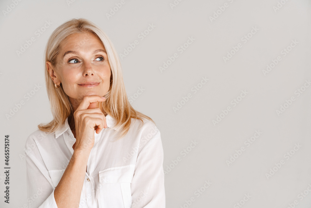 Mature blonde woman wearing shirt posing and looking aside Mature blonde woman wearing shirt posing and looking aside