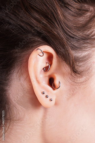 ear with earrings including helix rook tragus and lobe piercings Fototapet
